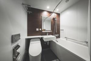 a bathroom with a sink and a toilet and a mirror at SAPPORO STREAM HOTEL in Sapporo