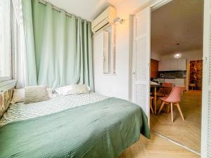 une chambre avec un lit avec une couverture verte dans l'établissement Nice Plage - Wifi, AC, hyper centre, 4 pers, à Nice