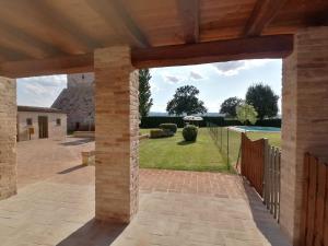 a brick patio with a fence and a yard at Pietra Rosa in Spello