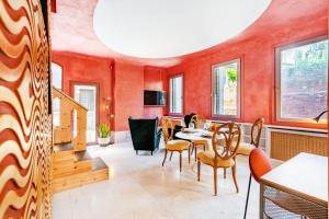 a dining room with orange walls and a table and chairs at Appartamento di lusso con terrazza sull'acqua in Venice