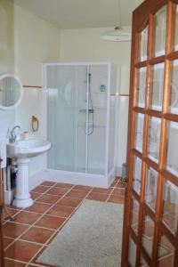 uma casa de banho com um chuveiro e um lavatório. em Les Bruyeres B&B em Montbron