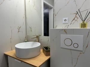 uma casa de banho com um lavatório branco num balcão de madeira em Modern și confortabil em Floresti
