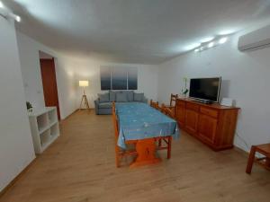 uma sala de estar com uma mesa e uma televisão em Villa Gio' Iun R4245 em Sìnnai