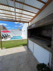 un patio trasero con piscina y pérgola en Caribe en Concepción del Uruguay