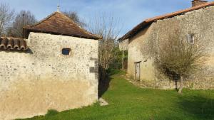an old stone building with a window on the side at La Chaumière in Salles-Lavalette