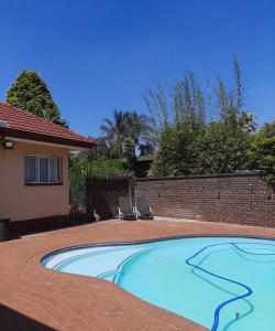 a swimming pool in front of a house at The Cottage at 19 in Kempton Park