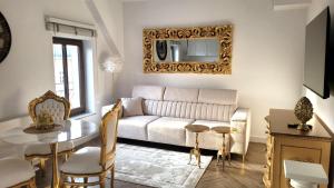 ein Wohnzimmer mit einem Sofa und einem Tisch in der Unterkunft APARTAMENT JARACZA 28/15 in Słupsk