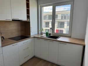 フロレシュティにあるModern și confortabilの白いキャビネットと窓付きのキッチン