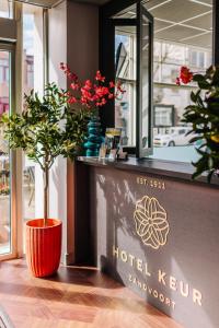 a plant sitting on top of a hotel kuhn sign at Hotel Keur in Zandvoort