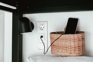 une chambre avec un panier, une lampe et un ordinateur portable dans l'établissement Aires Hostel, à São Roque do Pico