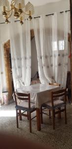 a bedroom with a bed and two chairs with curtains at Trullo Chiancola Antica in Alberobello