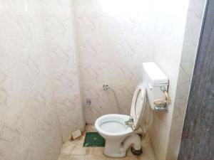 a bathroom with a white toilet in a stall at Hotel Kashi Inn Varanasi By GRG in Varanasi