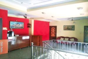 瓦拉納西的住宿－Hotel Kashi Inn Varanasi By GRG，客厅设有红色的墙壁和沙发