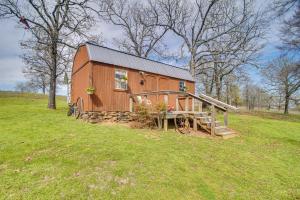 um grande celeiro de madeira num campo de relva em Countryside Tiny Home in Cameron about 5 Mi to Poteau! 