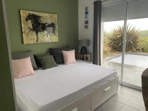een bed in een slaapkamer met een foto van een paard aan de muur bij Ama Lur in Hasparren