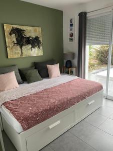 een slaapkamer met een bed met een schilderij aan de muur bij Ama Lur in Hasparren