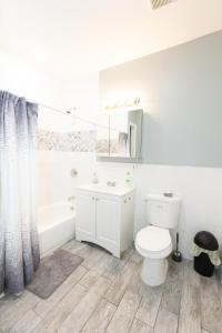 a bathroom with a toilet and a tub and a sink at Mins to NYC - Stylish 3 Bedroom Haven in Jersey City