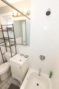 a white bathroom with a toilet and a sink at Mins to NYC - Stylish 3 Bedroom Haven in Jersey City