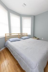 a bedroom with a large white bed with two pillows at Mins to NYC - Stylish 3 Bedroom Haven in Jersey City