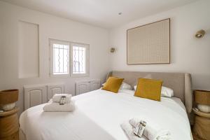 um quarto com uma grande cama branca com almofadas amarelas em Comfortable Apartment Suquet - 4pCannes Heart em Cannes