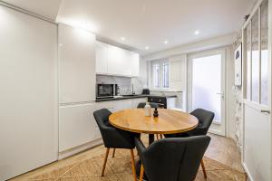 uma cozinha com uma mesa de madeira e cadeiras pretas em Comfortable Apartment Suquet - 4pCannes Heart em Cannes