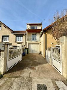 a house with two gates in front of it at La petite Maison chaleureuse in Jouars-Pontchartrain