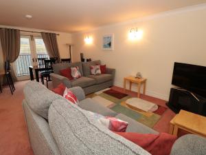 Una sala de estar con dos sofás y un televisor. en 12 Dartmouth House, en Dartmouth