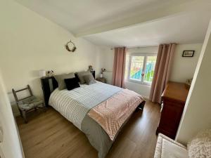 a bedroom with a large bed and a window at La petite Maison chaleureuse in Jouars-Pontchartrain +33 photos