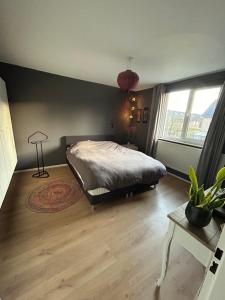 a bedroom with a bed and a large window at Compleet huis in Nijmegen in Nijmegen