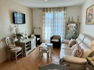 a living room with a couch and a table at La petite Maison chaleureuse in Jouars-Pontchartrain