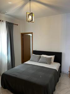 een slaapkamer met een groot bed en een zwarte deken bij Pensão Gonçalves in Calheta