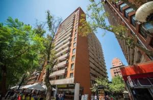 um edifício alto numa rua da cidade com edifícios em Luminosa habitacion con baño privado en el centro de Providencia em Santiago