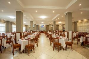 uma sala de jantar com mesas e cadeiras com toalhas de mesa brancas em Haile Hotel Wolaita em Sodo