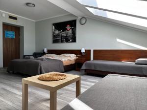 pokój z 2 łóżkami i stołem w pokoju w obiekcie Apartament Serwis w Krakowie