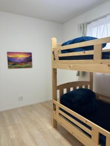 a bedroom with two bunk beds and a painting on the wall at ゆうゆう八街新築4LDK free wifi in Yachimata