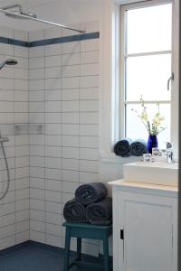 baño con ducha y toallas negras en un taburete en Rosenhøj Bed and Breakfast, en Svendborg