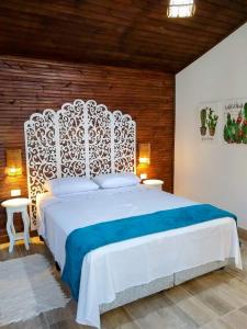 a bedroom with a white bed with a white headboard at Villa Bangalu in Porto De Galinhas