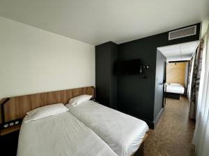 a bedroom with a white bed and a black wall at B&B HOTEL Marseille Centre La Joliette in Marseille