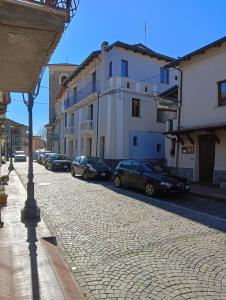 a cobblestone street with cars parked next to buildings at Bed and Breakfast da Peppino in Bianchi