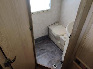 a small bathroom with a toilet and a window at Helsinki's Caravan Adventureヅ in Helsinki