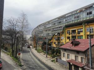 une rue vide devant un grand bâtiment dans l'établissement KIZZ Apartment, à Sarajevo