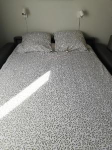 un letto con un piumone bianco e nero sopra di Studio saisonnier a La Roquette-sur-Siagne