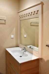 ein Bad mit einem Waschbecken und einem Spiegel in der Unterkunft Family House Cup in Tomar