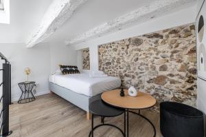 a bedroom with a bed and a stone wall at Typical 2 room apartment Suquet - 1BR4p in Cannes