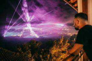 a man standing on a balcony looking at a fireworks display at BOHORIA Studio Apartments - Old Town in Veliko Tŭrnovo