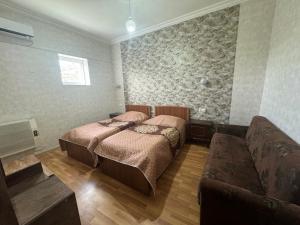 a bedroom with two beds and a couch at Nato & Lado in Sighnaghi