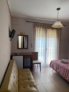 1 dormitorio con cama, escritorio y espejo en Άλκηστις Alkistis, en Loutra Edipsou