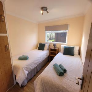 1 dormitorio con 2 camas y ventana en Stonesthrow Stalham en Stalham