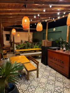 un vestíbulo con mesa, bancos y macetas en Hostal La Casta en Camarones