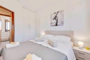 a white bedroom with a large bed with two pillows at HOLIDAY HOME LUANA in Maslenica